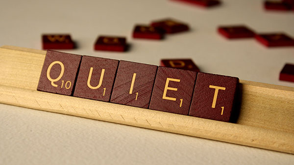 Scrabble tiles spelling out "QUIET"